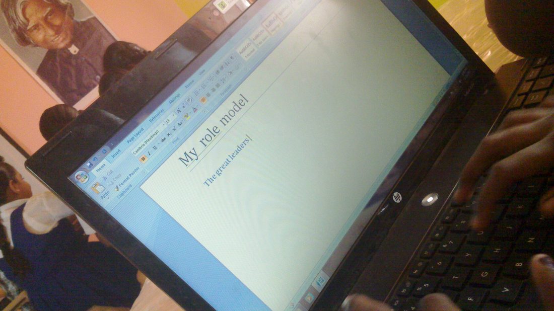 Students sitting at computers in a classroom, learning