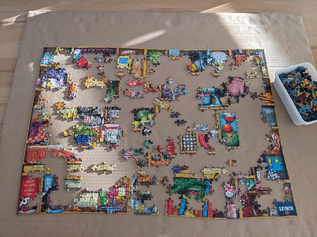 A jigsaw puzzle being assembled, with loose pieces still scattered around the completed section